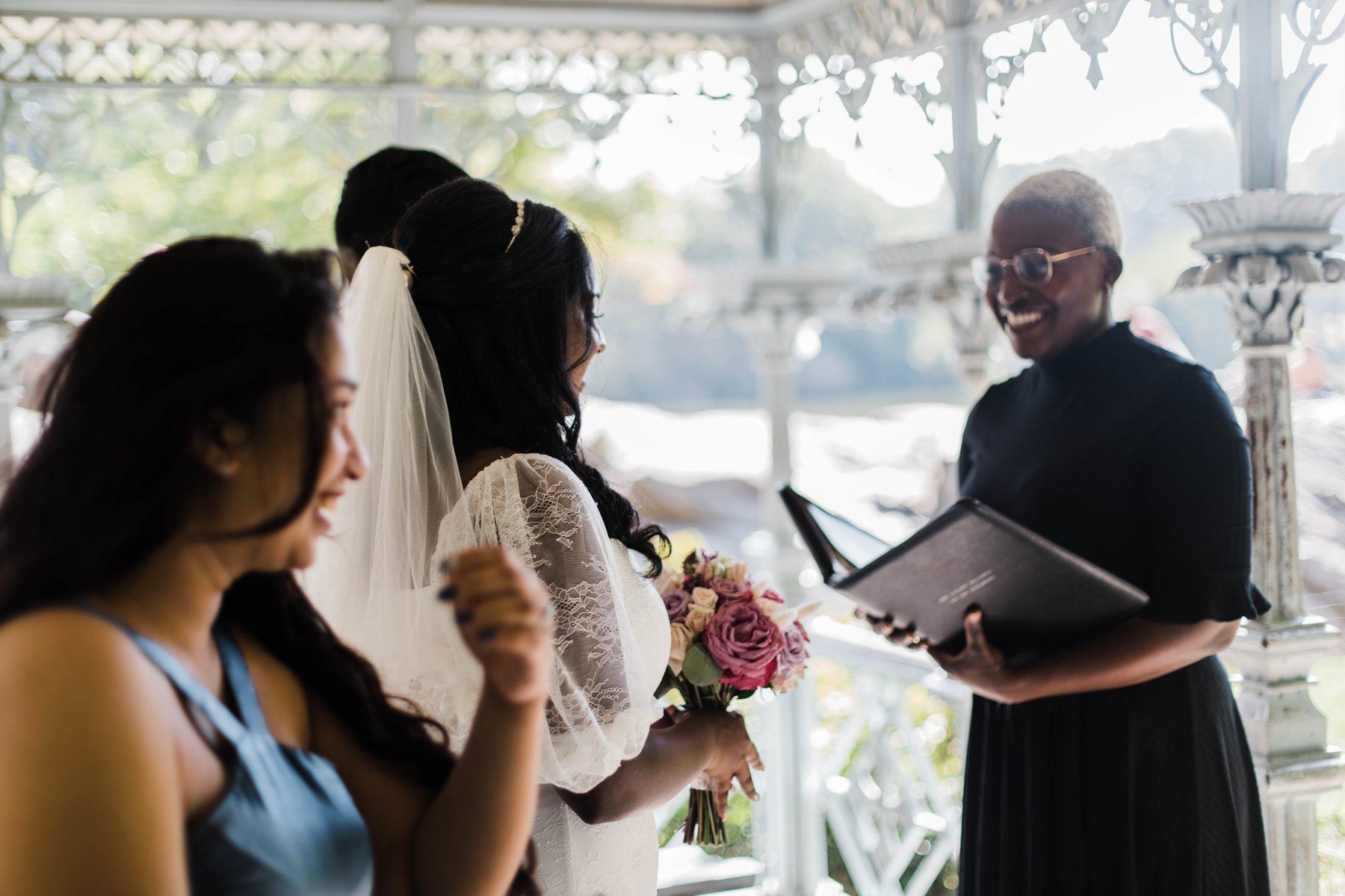 Robyn reading from her ceremony book for two brides at the Ladies' Pavilion in Central Park